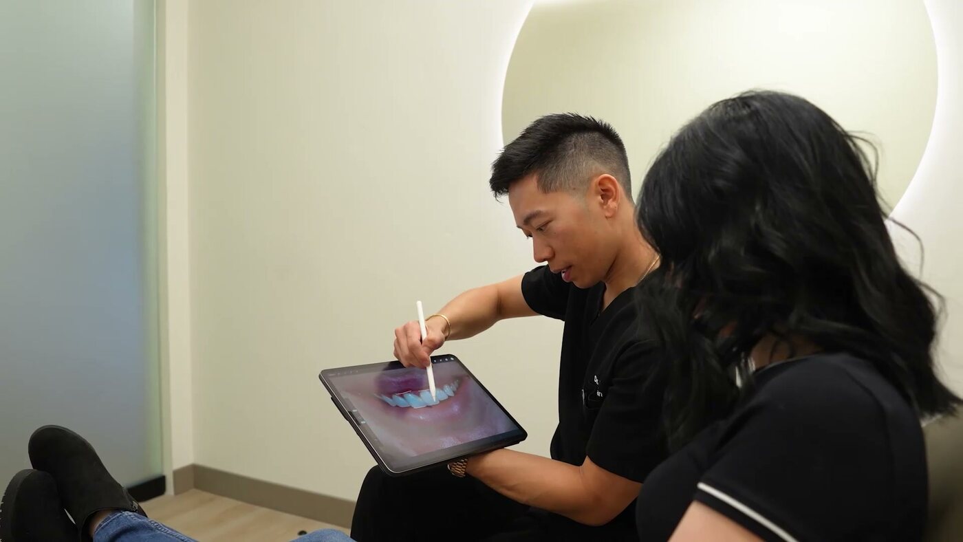 Dr. Kevin Tan reviewing a treatment plan chairside on an iPad