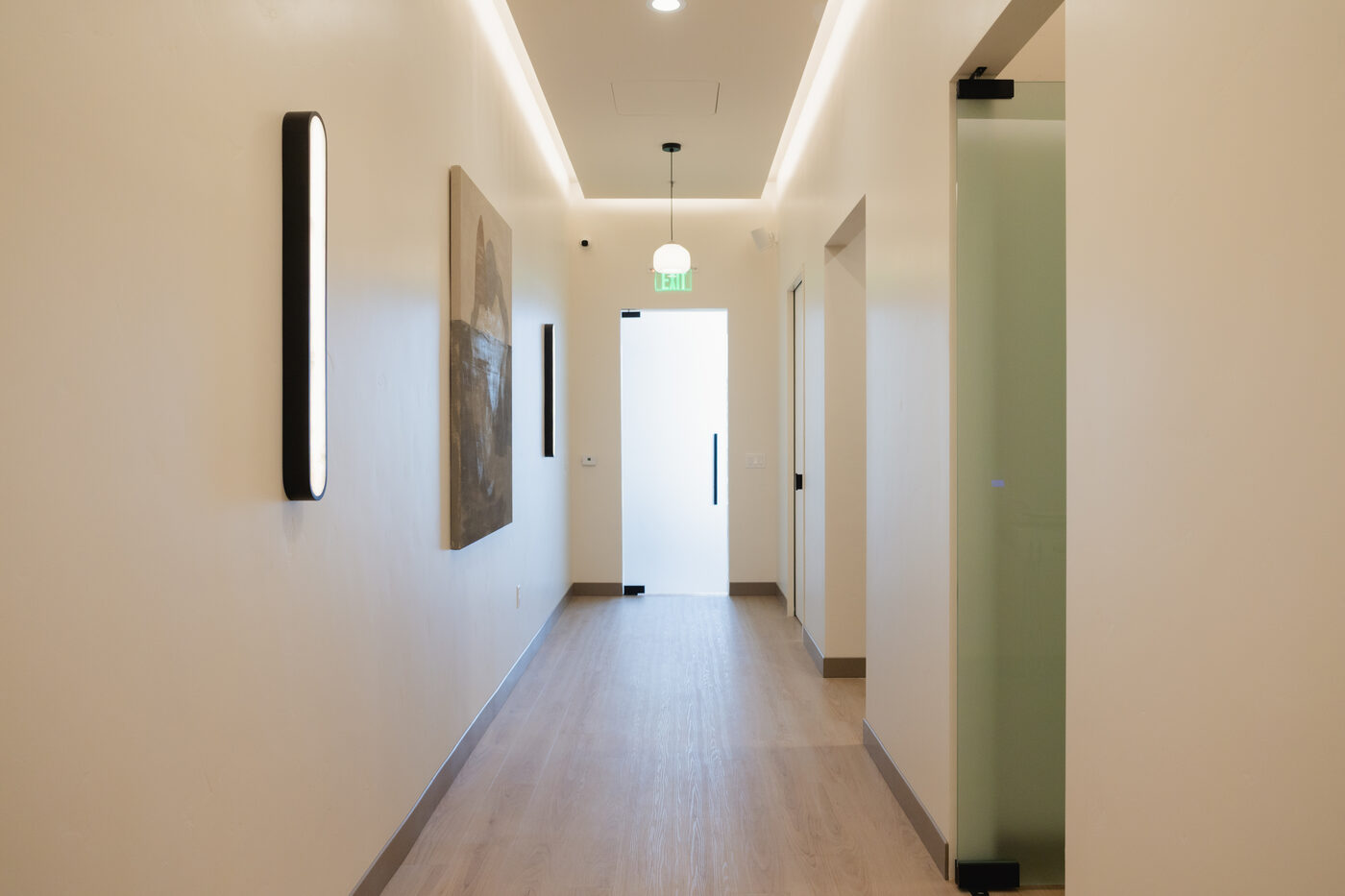 The corridor at Form + Function Dental Aesthetics, lit like a spa rather than a clinic